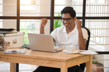 Fototapeta na wymiar young indian man celebrating success while working