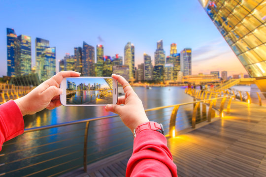 Smartphone photographing landscape of the Singapore financial district and business building