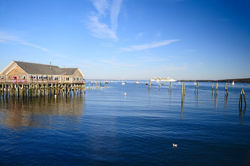 Obraz premium Atlantic Ocean Maine. coastal cafes on stilts in the water, boats at sea. Bay. Sunny day with clear skies. 