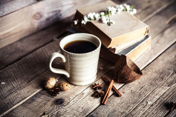 Large Cup of coffee on vintage wooden background. Spring flowers and books.