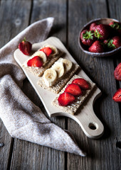 Fruity toast on wooden background. Strawberries, bread, butter a