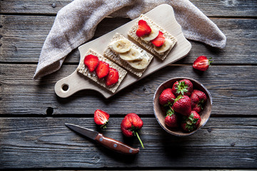 Fruity toast on wooden background. Strawberries, bread, butter and cheese.Vintage style