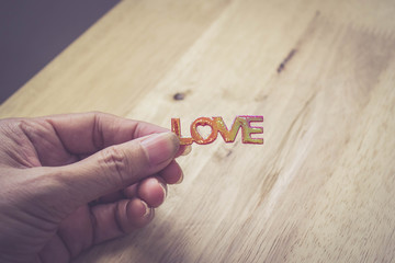 hand hold love word on wood background