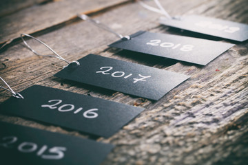 Pricing tags in a row with "2017" focus and other years text on wooden background