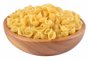 Uncooked italian pasta shells in a wooden bowl on a white