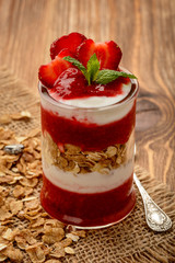 Healthy yougurt dessert with strawberry mousse, muesli and strawberries.