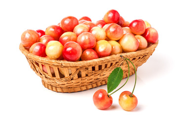 yellow cherries in a wicker basket isolated on white background