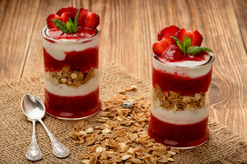 Healthy yogurt dessert with strawberry mousse, muesli and strawberries.