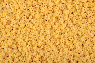 Uncooked italian pasta stars as background