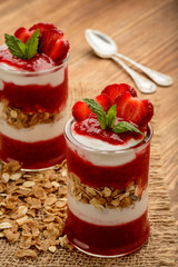 Healthy yougurt dessert with strawberry mousse, muesli and strawberries.