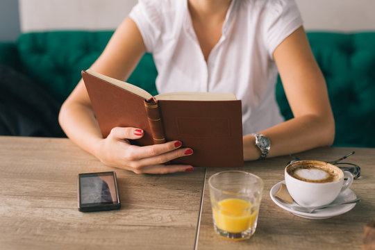 Enjoyoing Coffee Break. Woman Reading Book In Cafeteria