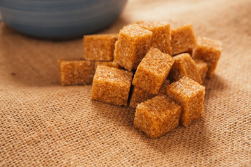 blue cup of tea and lump sugar on sacking background