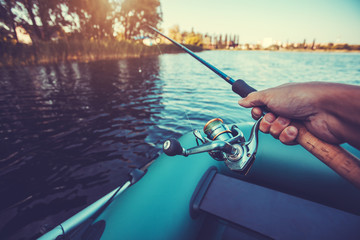 man fishing on a lake from rubber boat
