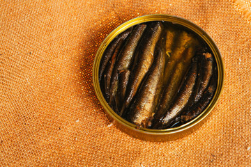 open can with of sprats on sackcloth background