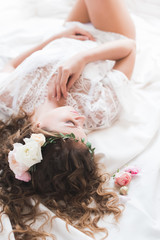 bride lying in a white peignoir