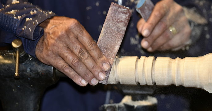 menuisier travaillant une pi&egrave;ce en bois sur un tour