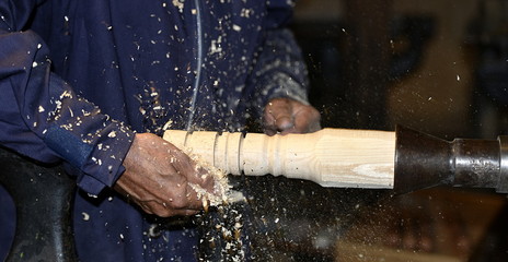 menuisier travaillant une pièce en bois sur un tour
