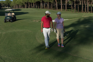 Obraz premium couple walking on golf course