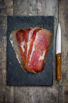 Spanish serrano ham on slate cutting board
