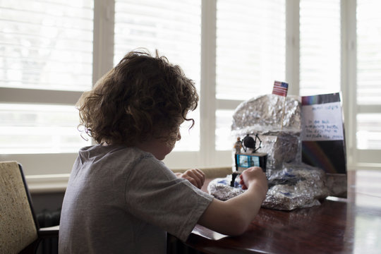 Boy Builds Model Lunar Landscape For School Project At Home