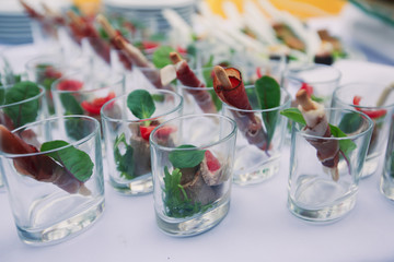 Beautifully decorated catering banquet table with different food snacks and appetizers with sandwich, caviar, fresh fruits on corporate christmas birthday kids party event or wedding celebration