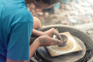 Hands working on pottery wheel
