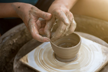 Hands working on pottery wheel