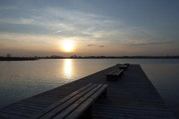Naklejka na ściany i meble Pier with benches on a lake at sunset