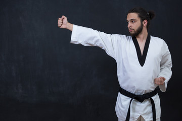 Fototapeta premium White Karate Fighter Isolated On Black With Copyspace