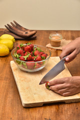 Slicing strawberries on a wooden table