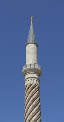 The minaret of a mosque on the blue sky back