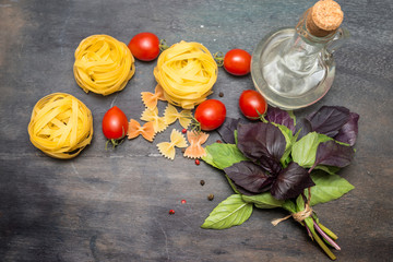 Pasta  with  basil leaves, cherry  and spices on dark background