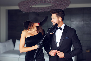 Sensual woman in black hat and whip with lover
