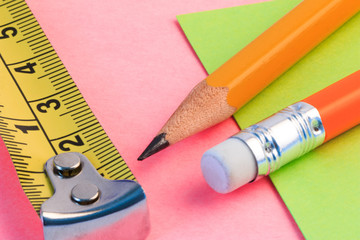 Pencil, measuring tape and paper note. Simple pencil, measuring and paper note. Closeup view.