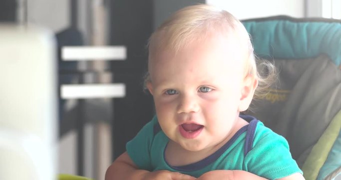 Little Baby Boy Watching Cartoons on an Tablet in the Kitchen of His House