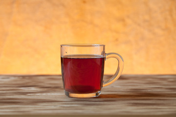 Cup of tea on light wooden table on blur jute background. Select