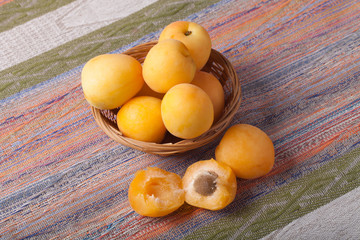 Fresh apricots in a basket on a tablecloth in rustic style. Sele