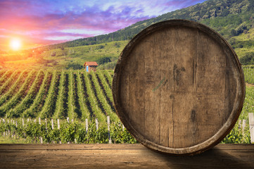 Red wine with barrel on vineyard in green Tuscany, Italy