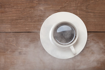 White cup of coffee on old wooden table