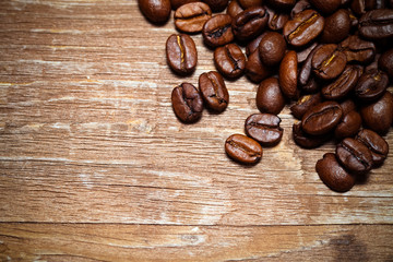 Coffee beans on a old wooden table for background. Space for tex