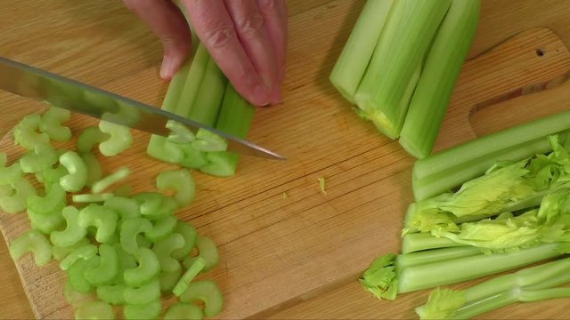 Chef chopping celery in kitchen 
