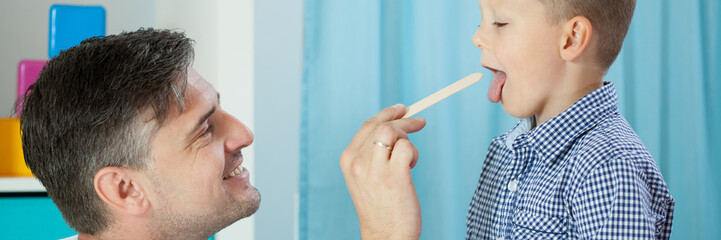 Obraz premium Pediatrician examining boy's throat