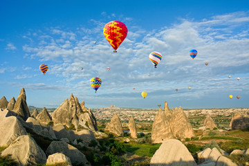 Fototapeta na wymiar Colorful hot air balloons flying over volcanic cliffs at Cappado