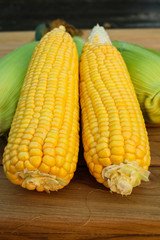 Two sweet corn on wood table