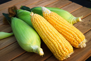 Five sweet corn on wood table