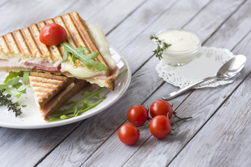 Sandwich with ham and tomatoes on wood background
