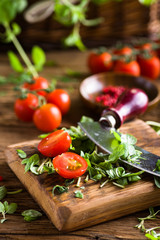 Cherry tomatoes and herbs on old wooden table