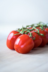 Vertical view of fresh tomatoes on a wooden desk. Close-up shot of red tomatoes. Selective focus. Shallow depth of field.