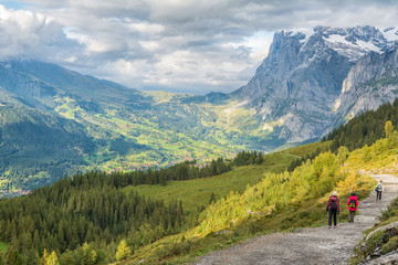 Fototapeta na wymiar Hikers walking on spectacular mountain scenery in Switzerland