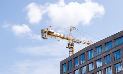 Construction crane and a building house against sky